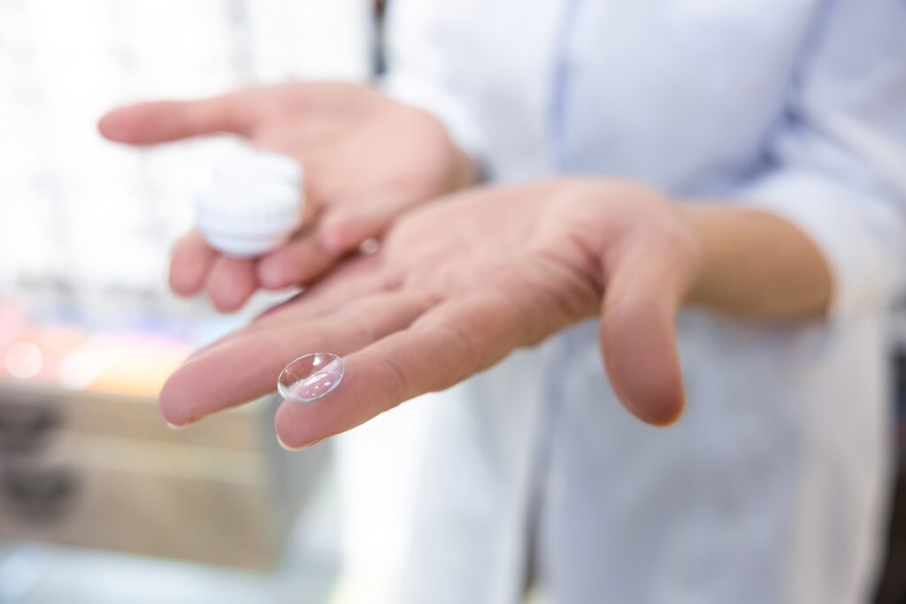 qualcuno che tiene in mano un paio di lenti a contatto